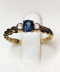 Sortija con zafiro central y 0'06 cts de brillantes laterales en oro amarillo de ley 18 kts.
