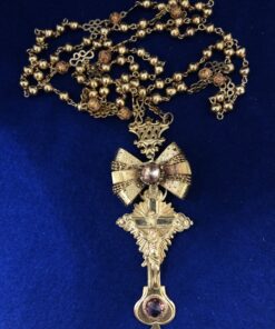 Rosario de principios del s. XX, de 80 cm de largo, con lazada y crucifijo enriquecidos con zafiros en oro amarillo de ley 18 kts.