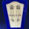Pendientes largos en forma de rosetones con 0'60 cts de brillantes en total en oro blanco de ley 18 kts.