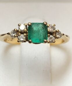 Sortija con auténtica esmeralda colombiana de 0'35 cts y 3 brillantes a cada lado de 0'12 cts en total, montados en oro amarillo de ley 18 kts.
