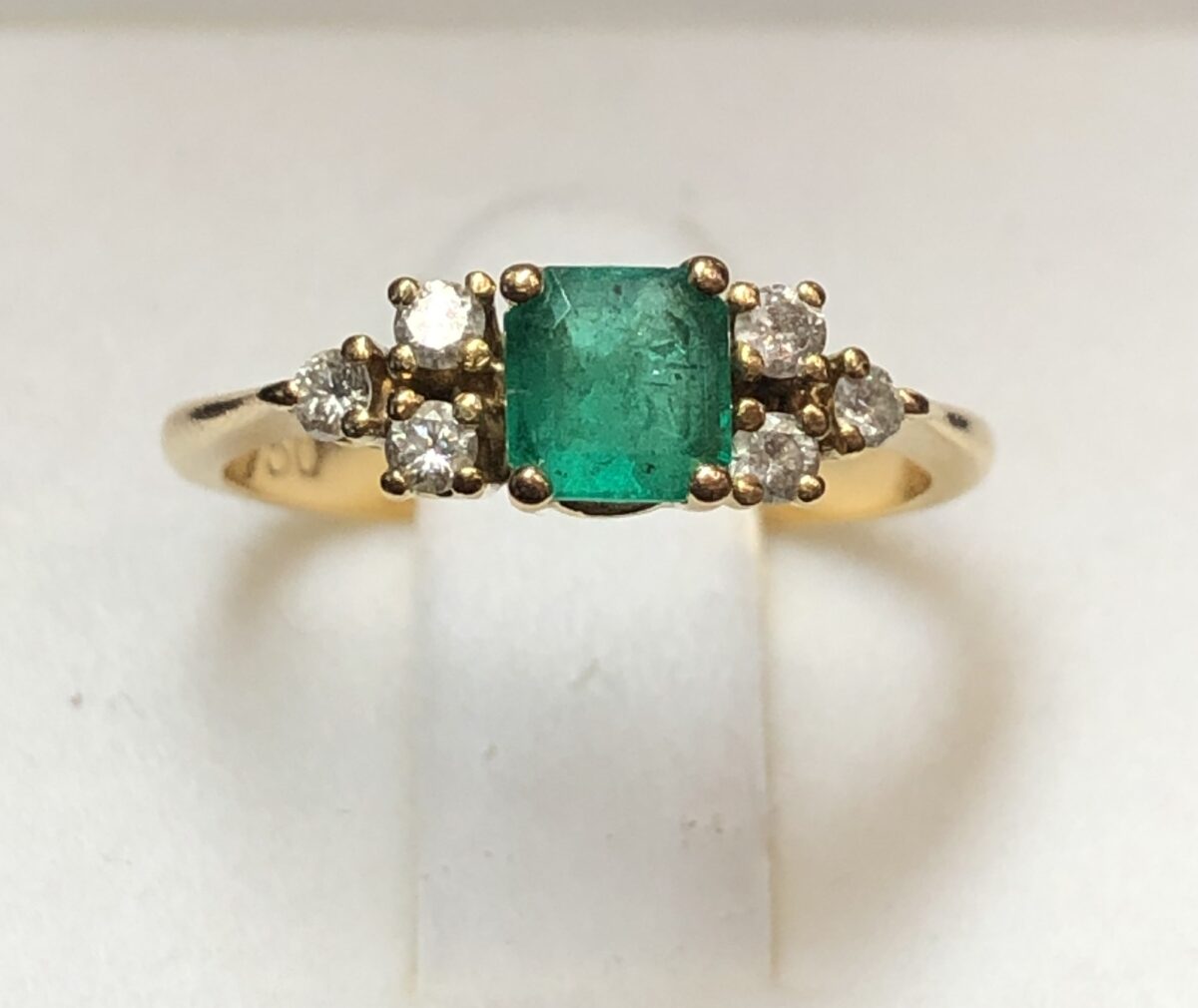 Sortija con auténtica esmeralda colombiana de 0'35 cts y 3 brillantes a cada lado de 0'12 cts en total, montados en oro amarillo de ley 18 kts.