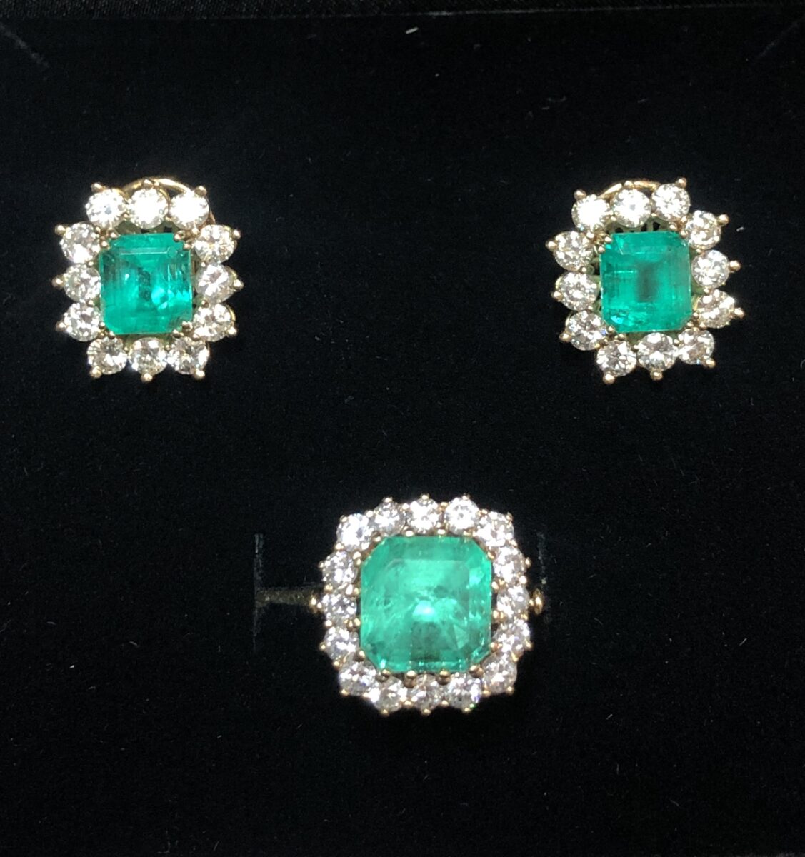 Espléndido juego de pendientes y sortija en forma de rosetones con auténticas esmeraldas colombianas de 9'5 cts en total y 5'3 cts en total de brillantes color H, en oro amarillo de ley 18 kts.