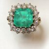 Sortija en forma de rosetón con auténtica esmeralda colombiana de 4 cts y orla de brillantes color H de 1'70 cts en total, montados en oro amarillo de ley 18 kts.