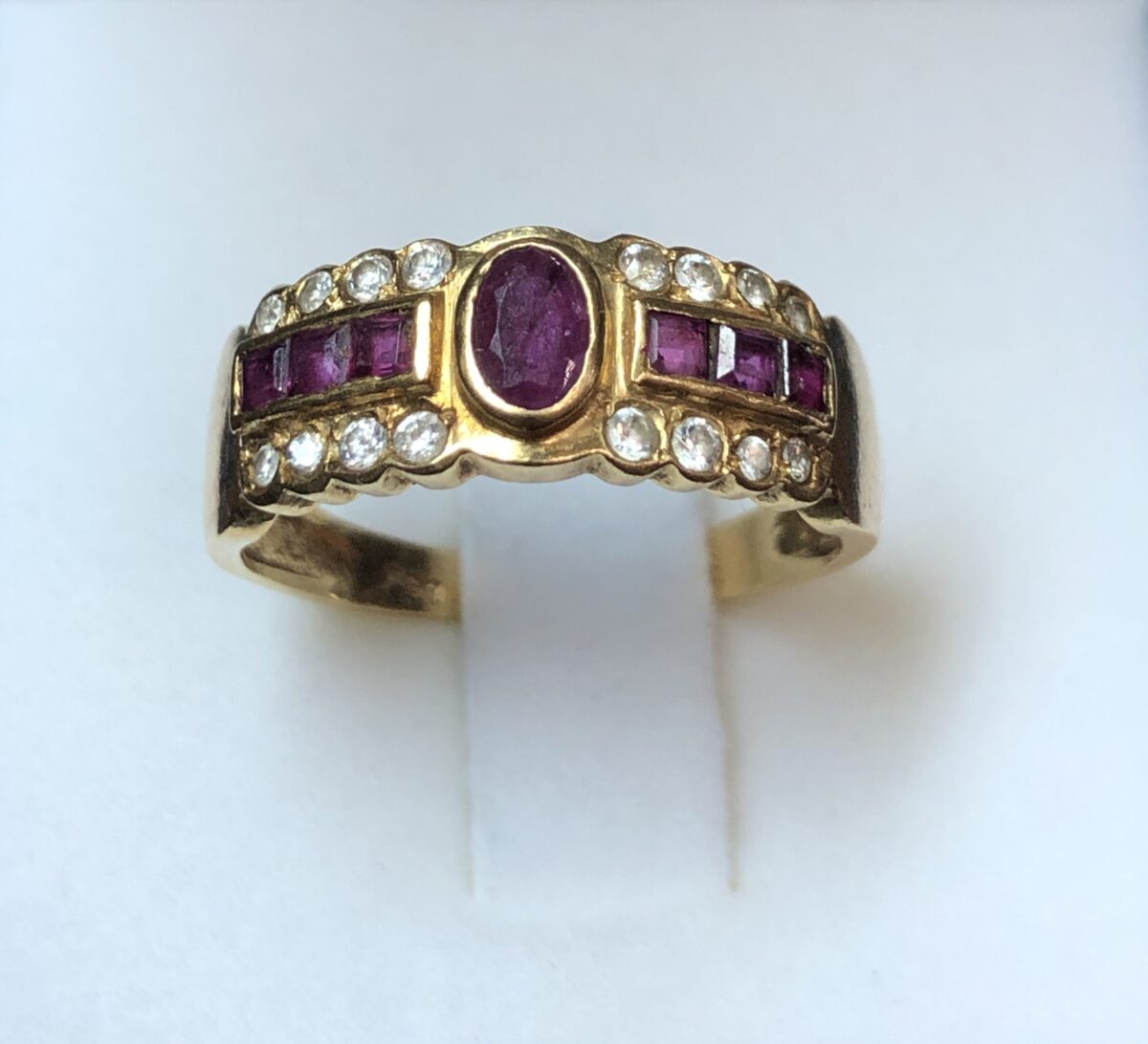 Sortija ancha con dos filas de brillantes de 0'22 cts en total y fila central de rubíes en oro amarillo de ley 18 kts.