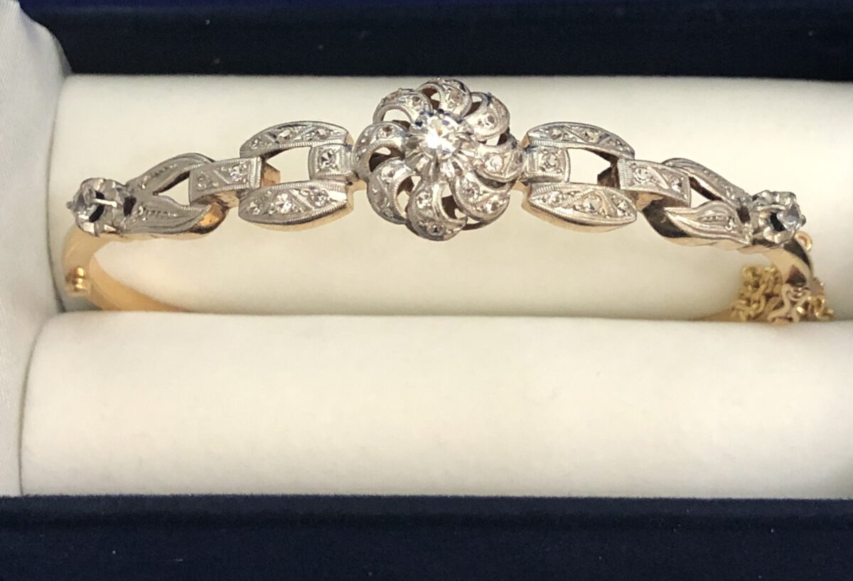 Brazalete rígido de los años 60 en oro amarillo de ley 18 kts con vistas en platino y zafiros blancos