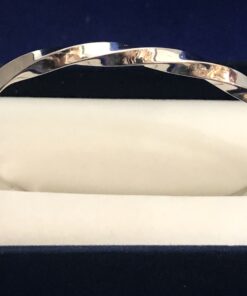 Brazalete rígido de media caña entorchado en oro blanco de ley 18 kts.