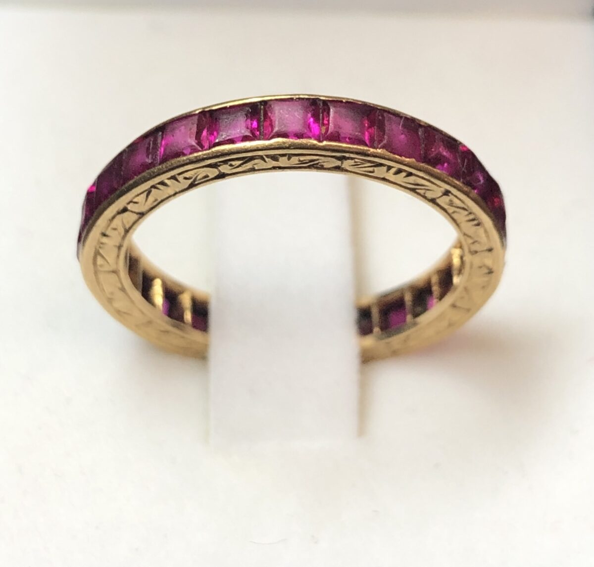 Alianza eternity con rubíes naturales en carré y motivos cincelados en oro de ley 18 kts.