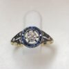 Sortija vintage "ojo de perdiz" (ca. 1940) con brillante central de 0'15 cts y orla de zafiros en oro de ley 18 kts.