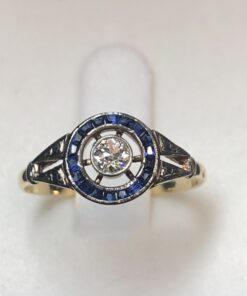 Sortija vintage "ojo de perdiz" (ca. 1940) con brillante central de 0'15 cts y orla de zafiros en oro de ley 18 kts.