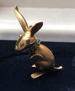 Colgante en forma de canguro, con detalles en rubí, esmeraldas y brillantitos, en oro amarillo de ley 18 kts.