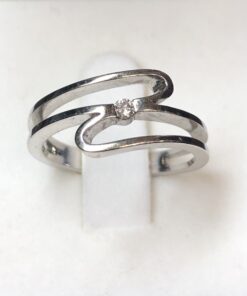 Sortija con diseño moderno y brillante central de 0'04 cts en oro blanco de ley 18 kts.