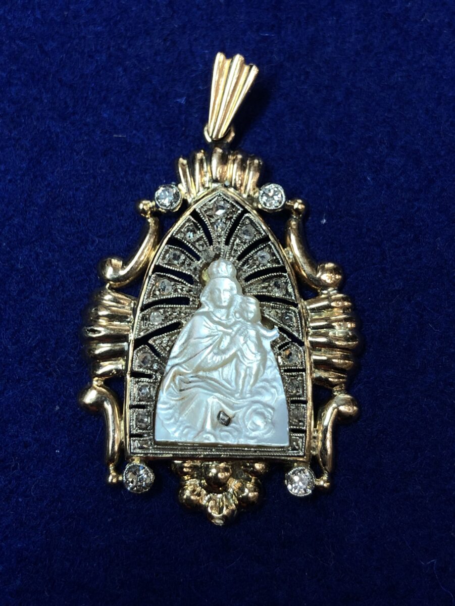 Medalla Art Decó (ca. 1920) de la Virgen del Carmen realizada en nácar, montada en oro amarillo de ley 18 kts con vistas en platino y enriquecida con diamantes