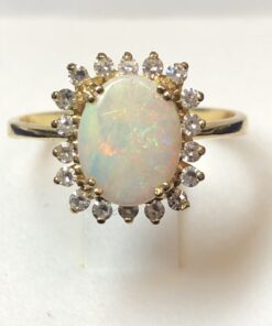 Sortija con ópalo blanco arcoíris y orla de brillantes de 0'36 cts en total, realizado en oro amarillo de ley 18 kts.