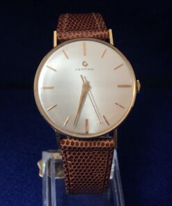 Reloj Certina vintage de caballero, esfera de 34mm, en oro de ley 18 kts. con pulsera marrón de piel genuina. Mecanismo de cuerda