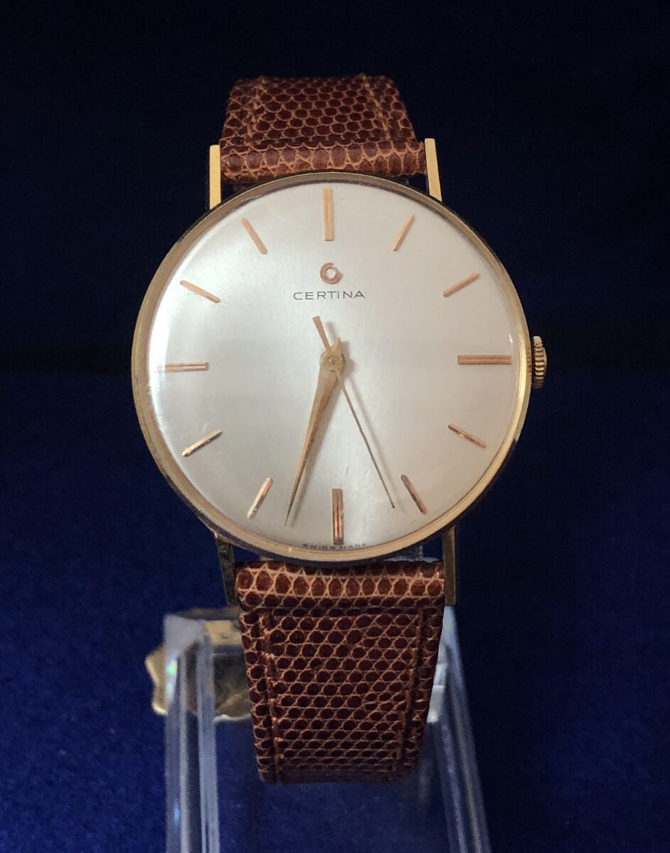 Reloj Certina vintage de caballero, esfera de 34mm, en oro de ley 18 kts. con pulsera marrón de piel genuina. Mecanismo de cuerda