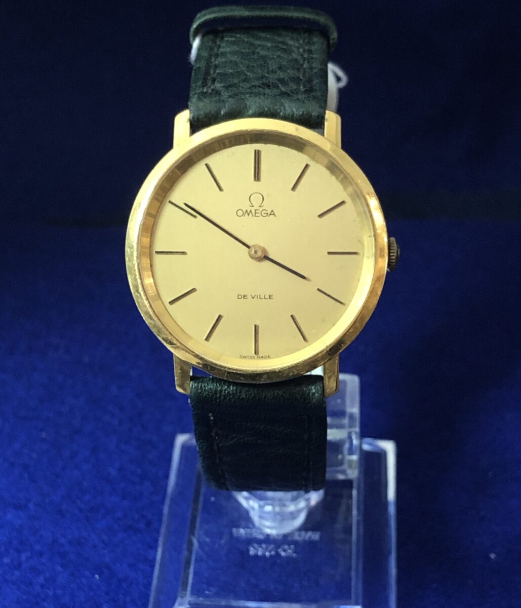 Reloj Omega De Ville, esfera de 34 mm, en oro de ley 18 kts., mecanismo de cuerda, con pulsera de piel color verde
