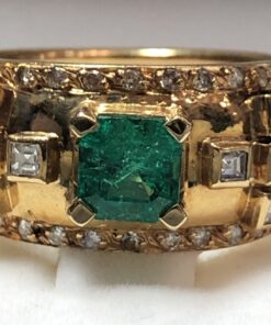 Sortija ancha con esmeralda central de 1'15 cts y enriquecida con 0'72 cts de brillantes en total, realizada en oro amarillo de ley 18 kts.