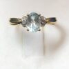 Sortija con topacio azul y brillantitos laterales montados en oro amarillo de ley 18 kts