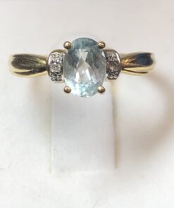 Sortija con topacio azul y brillantitos laterales montados en oro amarillo de ley 18 kts