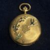 Pequeño reloj de bolsillo con pintorescos motivos esmaltados de golondrinas y flores, realizado en oro amarillo de ley 18 kts.