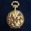 Pequeño reloj de bolsillo estilo Art Nouveau (1910) con esmalte guilloché color rojo y motivos florales, realizado en oro amarillo de ley 18 kts.