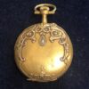 Pequeño reloj de bolsillo de principios del s. XX (ca. 1905) con motivos de roleos y diamante, realizado en oro amarillo de ley 18kts