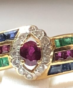 Sortija vintage con rubí central y orla de brillantes de 0'12 cts en total, con zafiros, esmeraldas y rubíes en carré a los laterales, montados en oro amarillo de ley 18 kts.