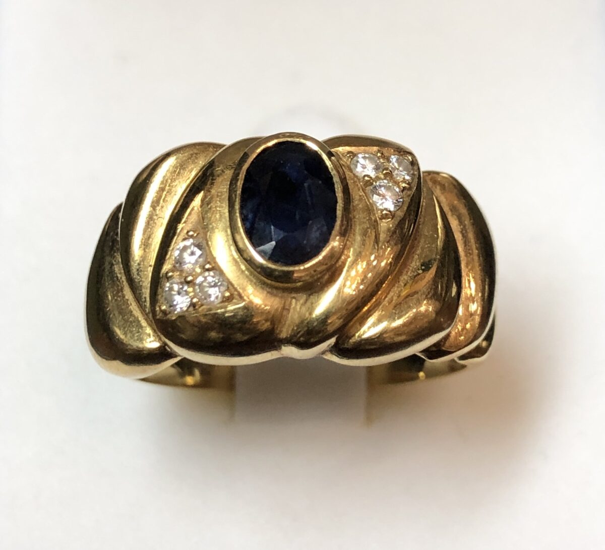 Sortija ancha vintage (años 80) con zafiro central de 0'50 cts y 0'12 cts de brillantes en total, realizada en oro amarillo de ley 18 kts.