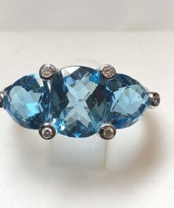 Tresillo de topacios Swiss Blue engastados en garras con 0'06cts de brillantes, realizado en oro blanco de ley 18 kts.