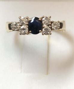 Sortija con zafiro central y brillantes laterales de 0'30 cts en total, realizada en oro amarillo de ley 18 kts.