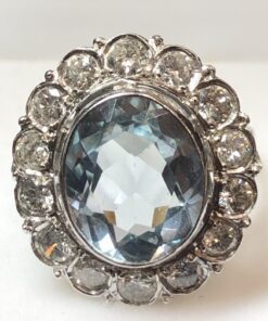 Sortija vintage en forma de rosetón con topacio azul central y orla de 1'40 cts de brillantes, realizada en oro blanco de ley 18 kts.