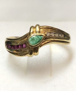 Sortija vintage con esmeralda central talla pera, adornada con una fila de rubíes y otra fila de brillantes en cada brazo, realizada en oro amarillo de ley 18 kts.