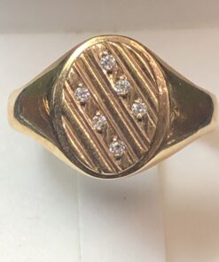 Sello estriado con dos filas de brillantes de 0'12 cts en total, realizado en oro amarillo de ley 18 kts.