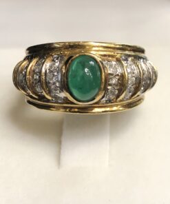 Sortija bombé con esmeralda central en cabujón y gallones enriquecidos con diamantes, realizada en oro amarillo de ley 18 kts.