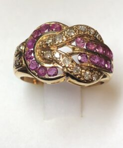 Sortija con diseño de hebilla cuajada de rubíes y 0'16 cts de brillantes en total, realizada en oro amarillo de ley 18 kts.