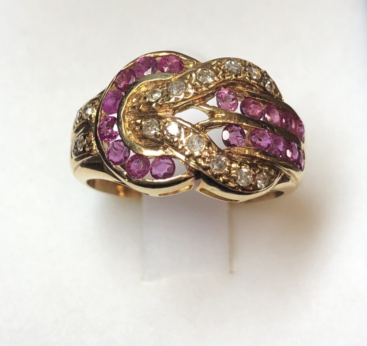 Sortija con diseño de hebilla cuajada de rubíes y 0'16 cts de brillantes en total, realizada en oro amarillo de ley 18 kts.