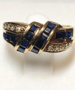 Sortija con diseño de lazada realizada con zafiros finos y 0'10 cts de brillantes en oro amarillo de ley 18 kts.