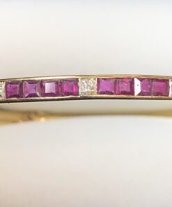 Pulsera de media caña con rubíes en carre y 0'14 cts de brillantes, realizada en oro amarillo de ley 18 kts.