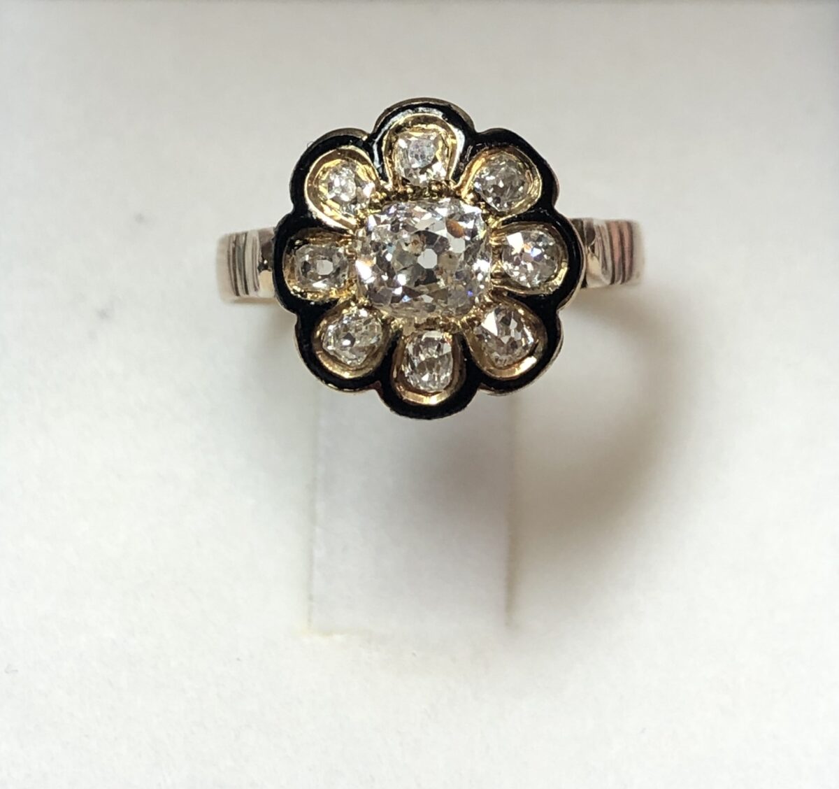 Preciosa sortija de época isabelina (finales del s. XIX) en forma de flor, con diamantes talla rosa de 0'70 cts en total, con esmaltado negro, realizado en oro amarillo de ley 18 kts.