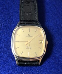 Reloj Omega De Ville Vintage con fecha, mecanismo de cuarzo, con esfera dorada y correa de piel genuina original de la marca, realizado en oro de ley 18 kts.