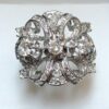 Espectacular sortija vintage estilo Hollywood (años 60), en forma de lazo con 3 brillantes centrales, y 1'10 cts de brillantes en total, realizada en oro blanco de ley 18 kts.