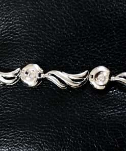 Pulsera con motivos orgánicos y brillantes en chatón de 0'13 cts en total, realizada en oro blanco de ley 18 kts.