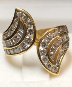 Espectacular sortija vintage (años 80) con brazos contrapeados cuajados de 3 cts de diamantes talla brillante y talla esmeralda, realizada en oro amarillo de ley 18 kts.