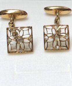 Gemelos calados con motivos florales y diamantes realizados en oro amarillo de ley 18 kts.