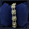 Pulsera calada antigua de finales del siglo XIX (ca. 1890) realizada en oro amarillo de ley 18 kts con vistas en plata y motivos florales con diamantes y esmeraldas.