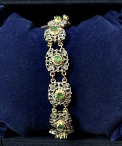 Pulsera calada antigua de finales del siglo XIX (ca. 1890) realizada en oro amarillo de ley 18 kts con vistas en plata y motivos florales con diamantes y esmeraldas.