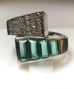 Sortija con brazos contrapeados cuajados de 0'38 cts de brillantes en total y 0'70 cts de esmeraldas talla baguette, montados en oro blanco de ley 18 kts.