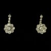 Pendientes en forma de flores con 3 cts (aprox.) de diamantes y con cadenita de seguridad para dar movimiento, realizados en oro de ley 18 kts.