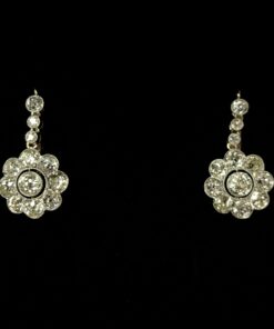 Pendientes en forma de flores con 3 cts (aprox.) de diamantes y con cadenita de seguridad para dar movimiento, realizados en oro de ley 18 kts.