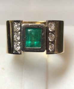 Sortija ancha con auténtica esmeralda colombiana de 0'80 cts y brillantes laterales de 0'30 cts en total, realizada en oro blanco y amarillo de ley 18 kts.
